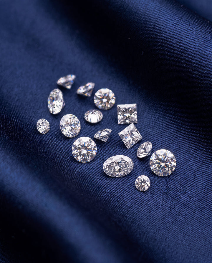 Loose diamonds of different cuts laid out on navy cloth for assessment at NY2K Jewellers, Cotton Tree