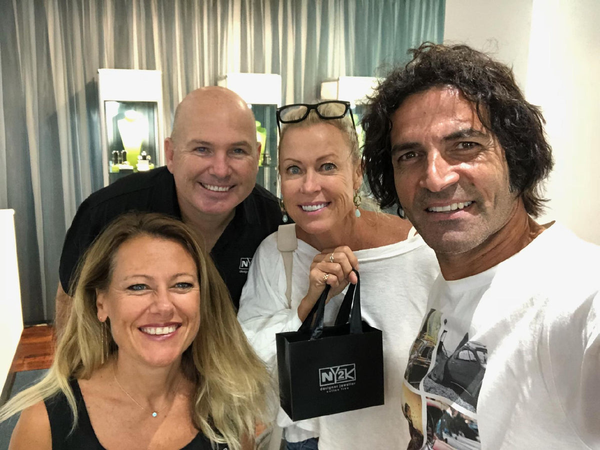 Four people smiling together at NY2K Jewellers, Maroochydore, one holding a gift bag