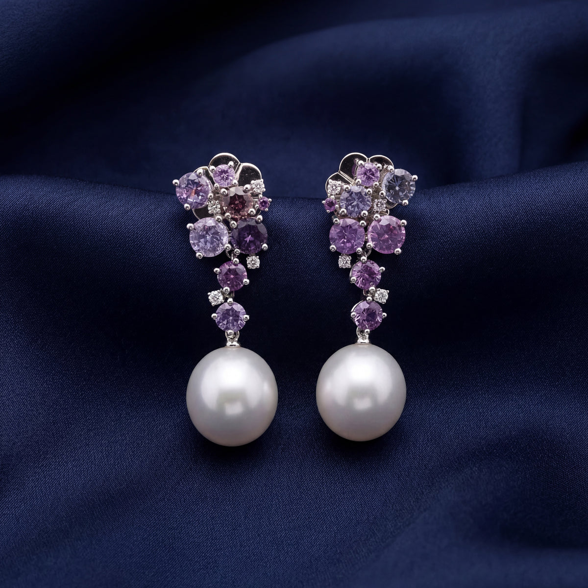 Purple gemstone cluster and pearl drop earrings on navy silk, NY2K Jewellers, Maroochydore